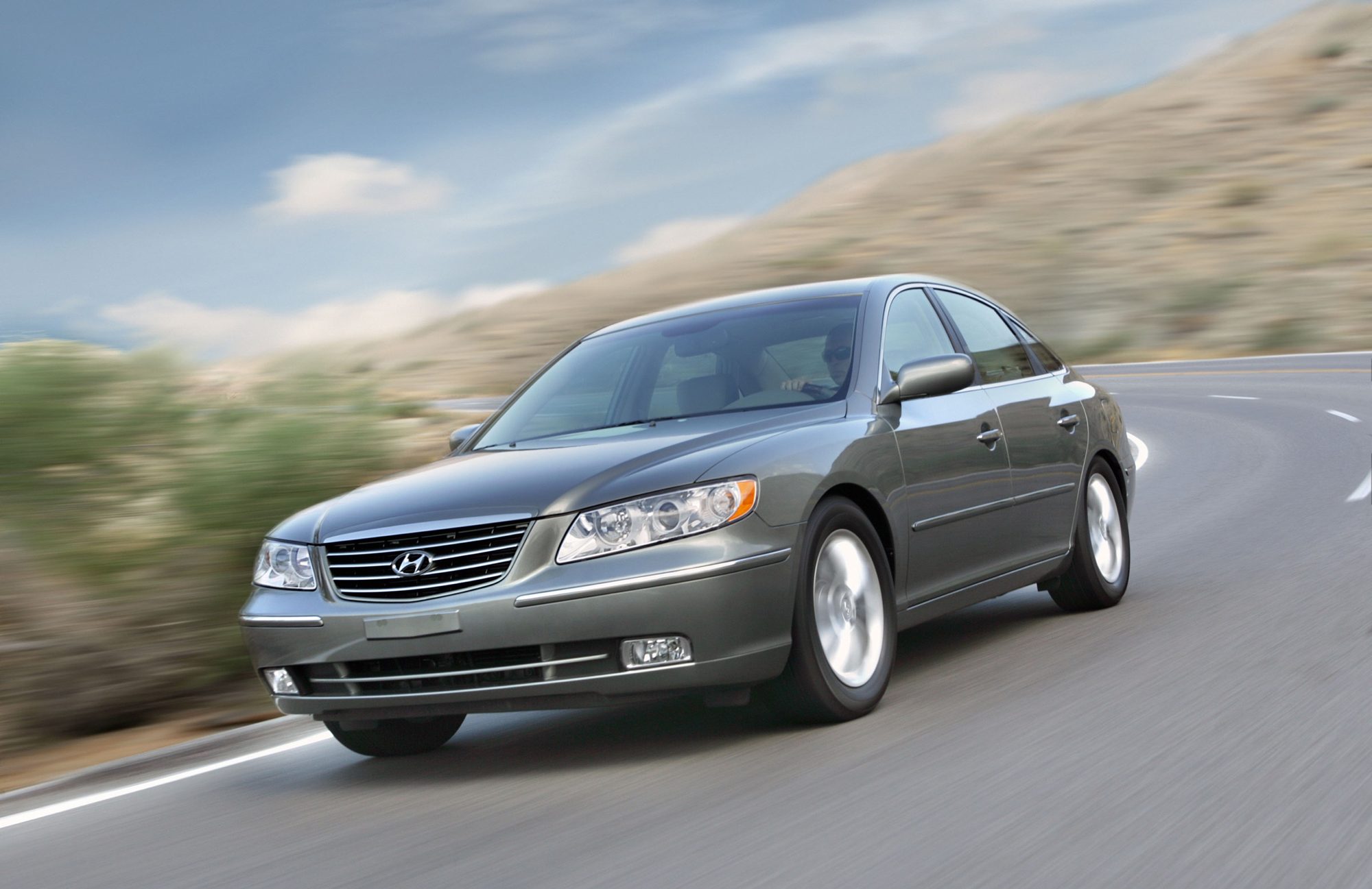 Gray-green 2006 Hyundai Azera driving on a desert highway