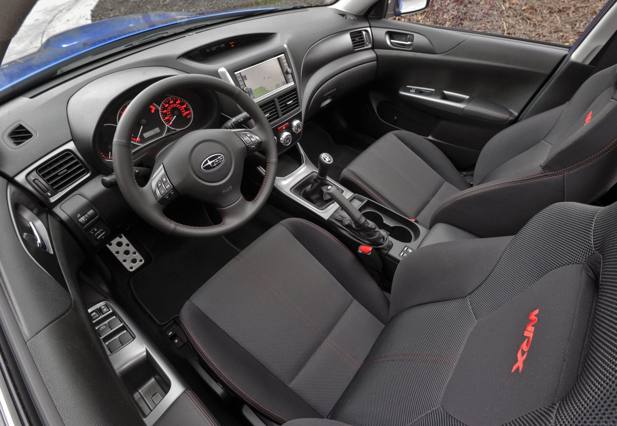Black front seats with red stitching and an embroidered WRX logo in the 2011 Subaru Impreza WRX