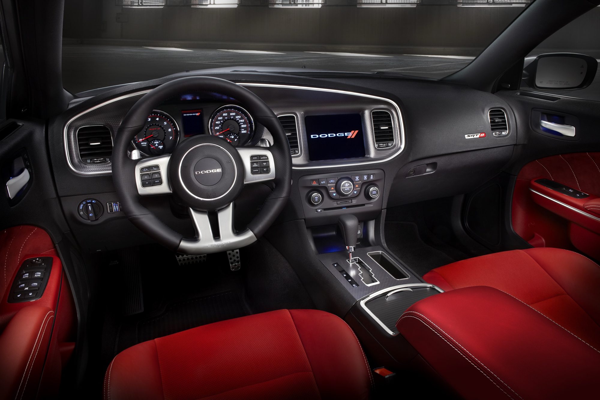 Dashboard of the 2012 Dodge Charger SRT8 with the SRT steering wheel, 8.4-inch touchscreen and red leather seats