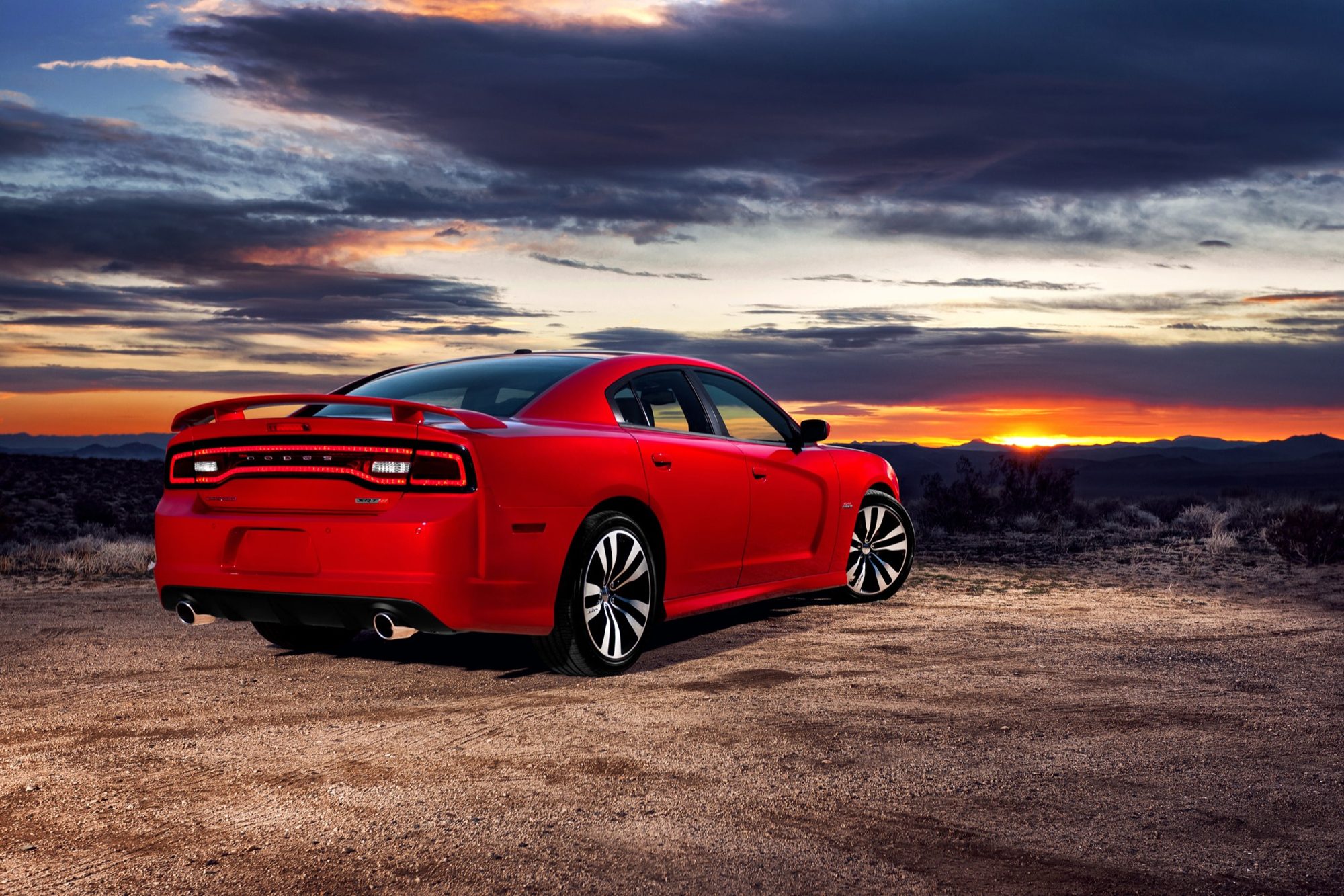 Dodge Charger, 2012: Fast, powerful, high-performance bargain 4 Rear three-quarter view of a red 2012 Dodge Charger SRT8 showing the racetrack LED taillight, spoiler and dual exhaust tips at sunset