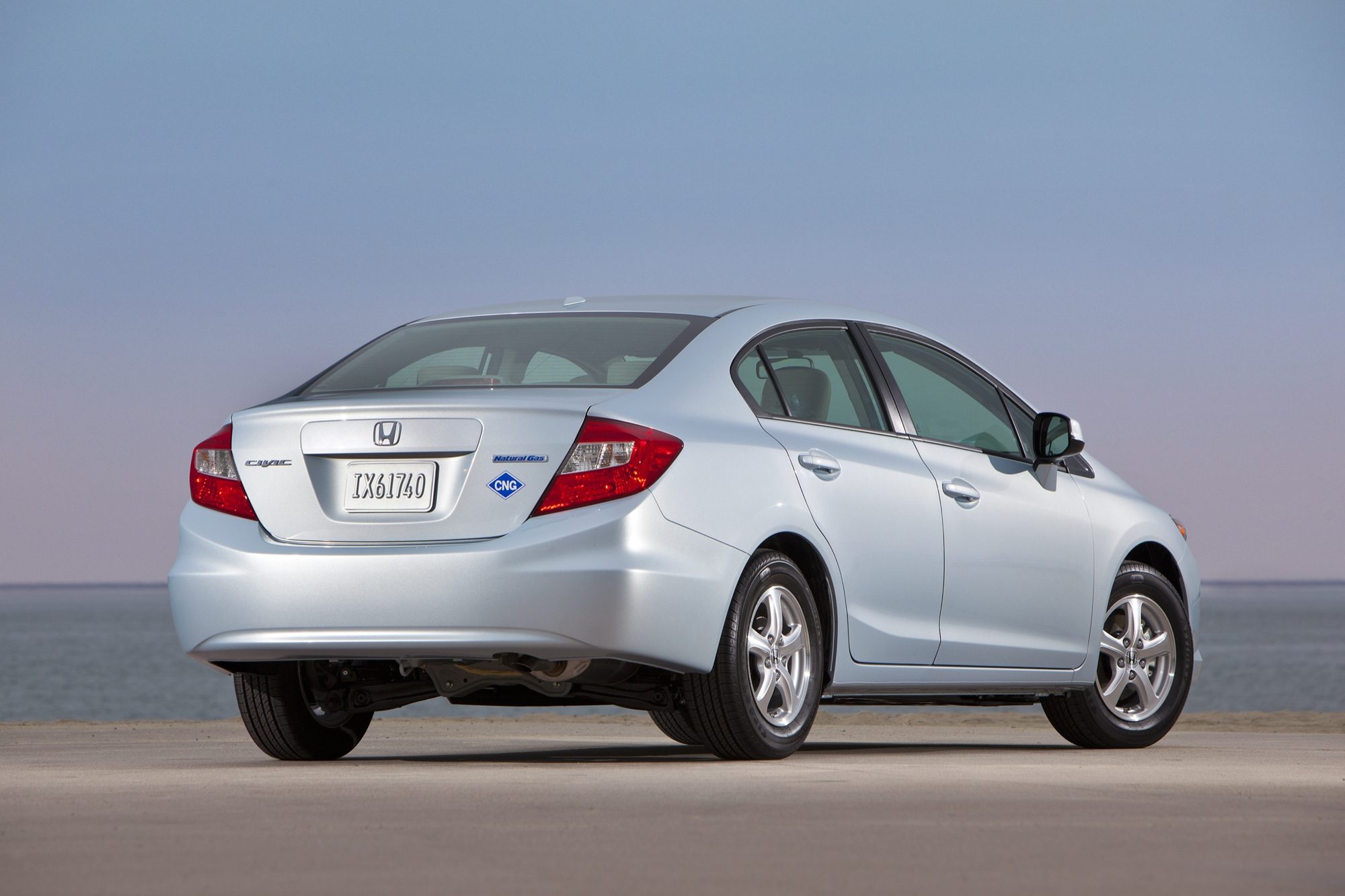 Rear three-quarter view of a light blue-silver 2012 Honda Civic Natural Gas sedan with its CNG badge