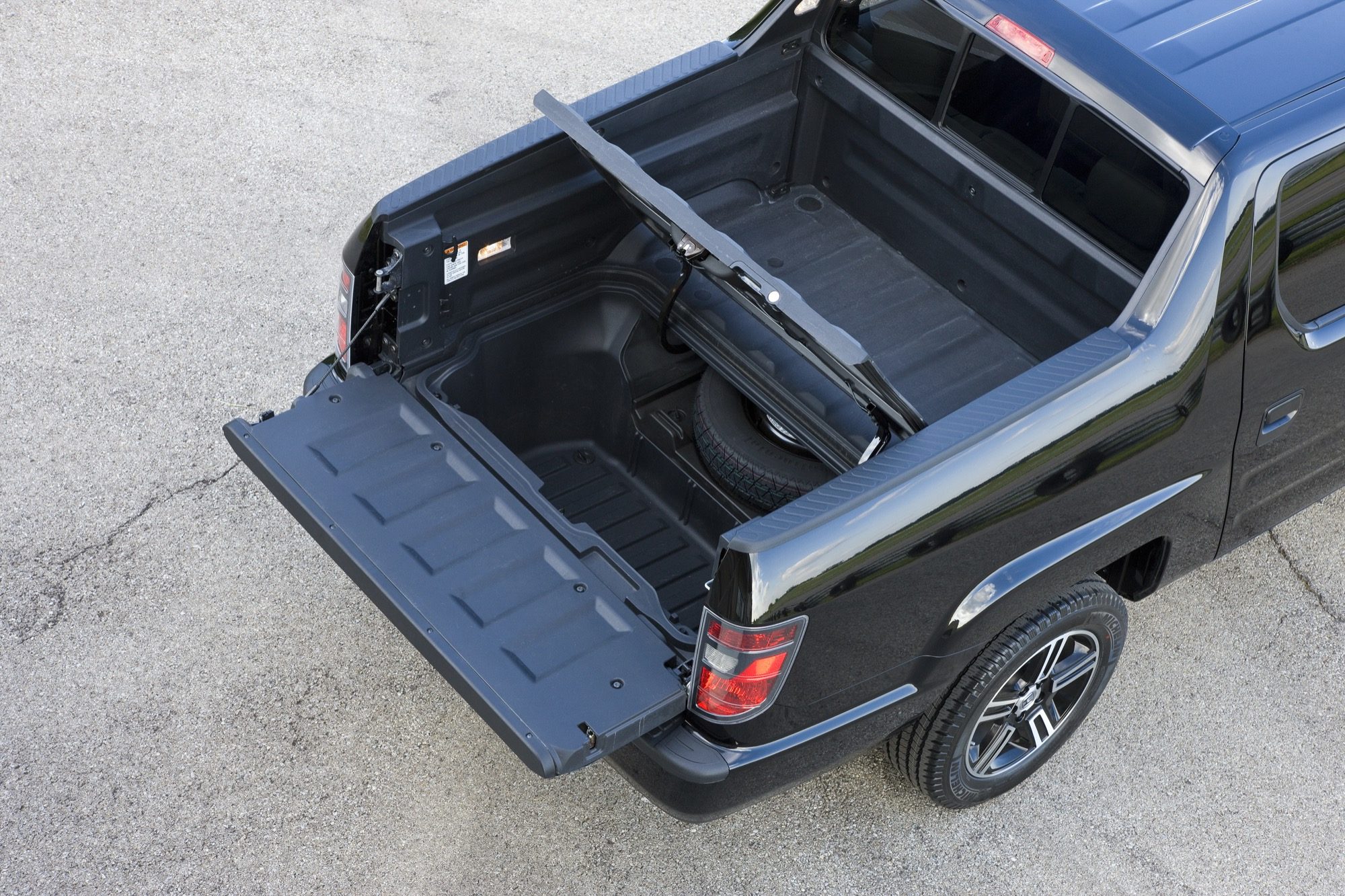 2012 Honda Ridgeline Review: Innovative pickup now available in sport model 3 Open tailgate and lockable in-bed trunk of a black 2012 Honda Ridgeline Sport