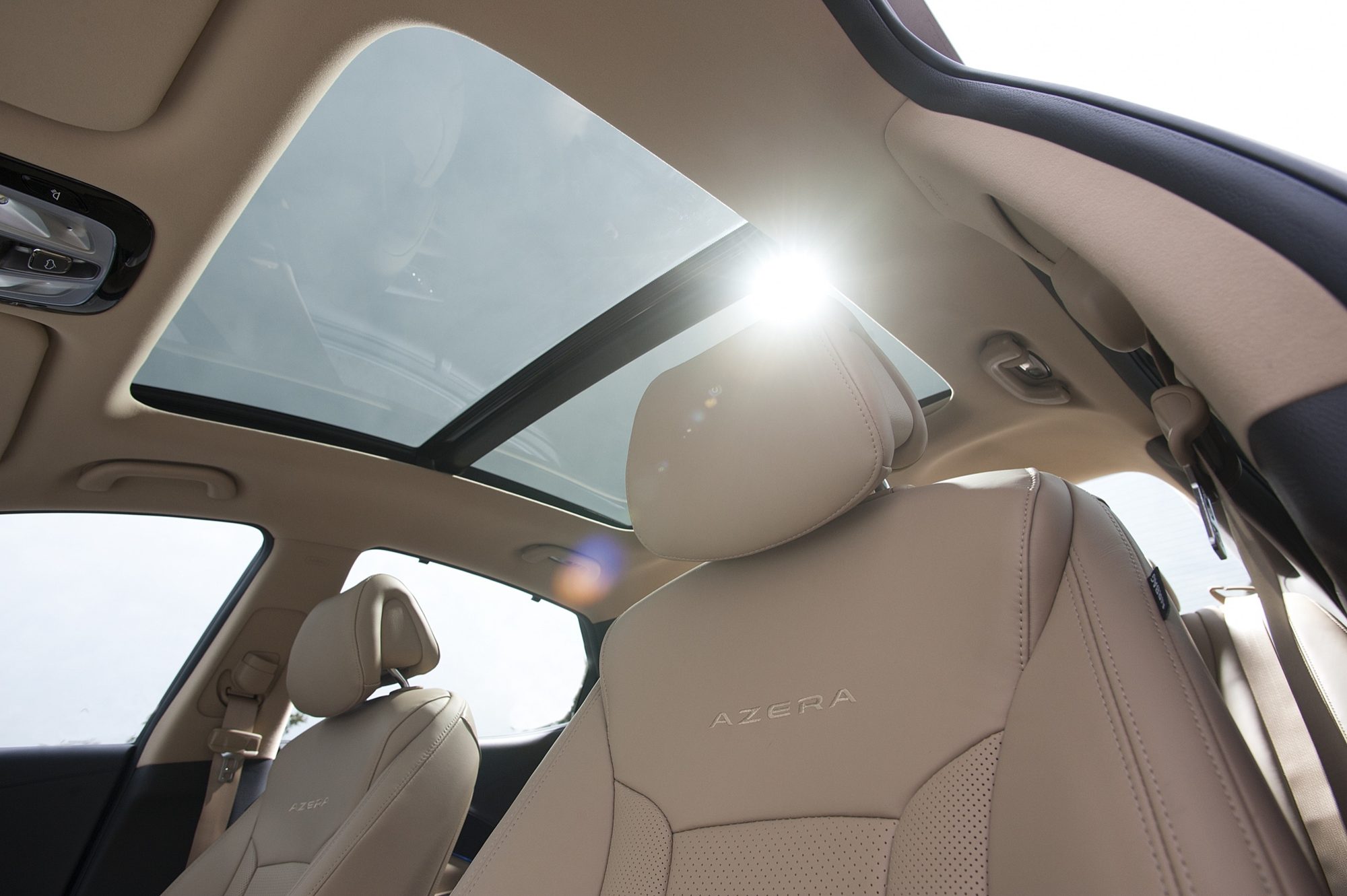 Panoramic sunroof above the beige leather front seats of the 2012 Hyundai Azera