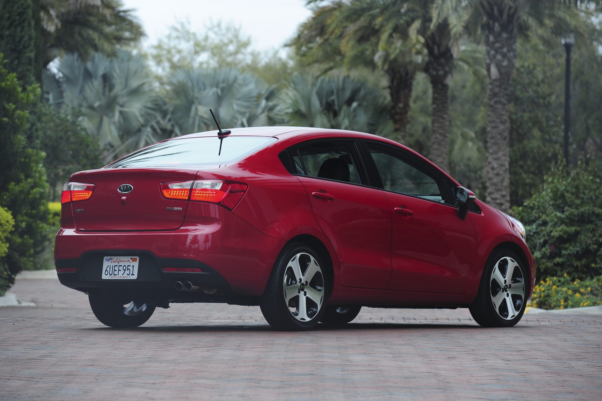 Rear three-quarter view of a red 2012 Kia Rio SX sedan