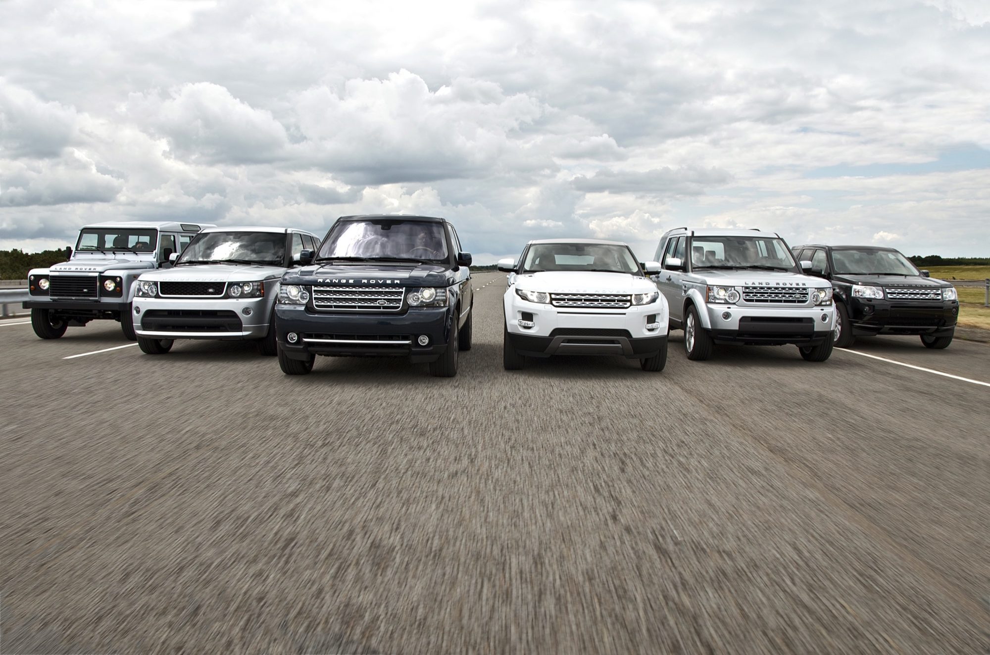 The 2012 model-year Land Rover lineup driving abreast, with a dark blue Range Rover third from left