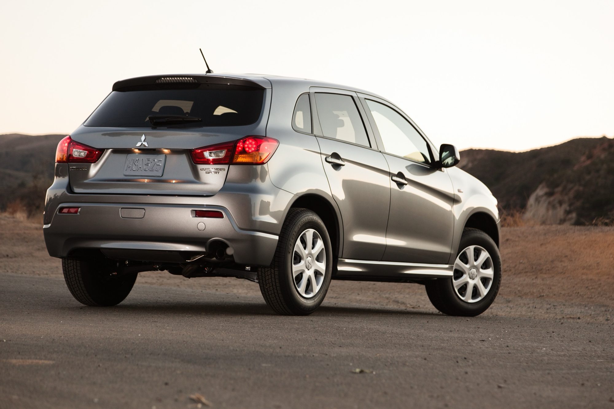 Rear three-quarter view of a gray 2012 Mitsubishi Outlander Sport ES at dusk