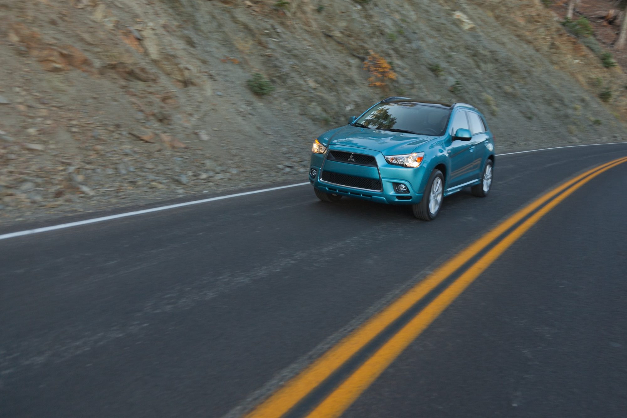 Blue 2012 Mitsubishi Outlander Sport SE driving on a mountain road