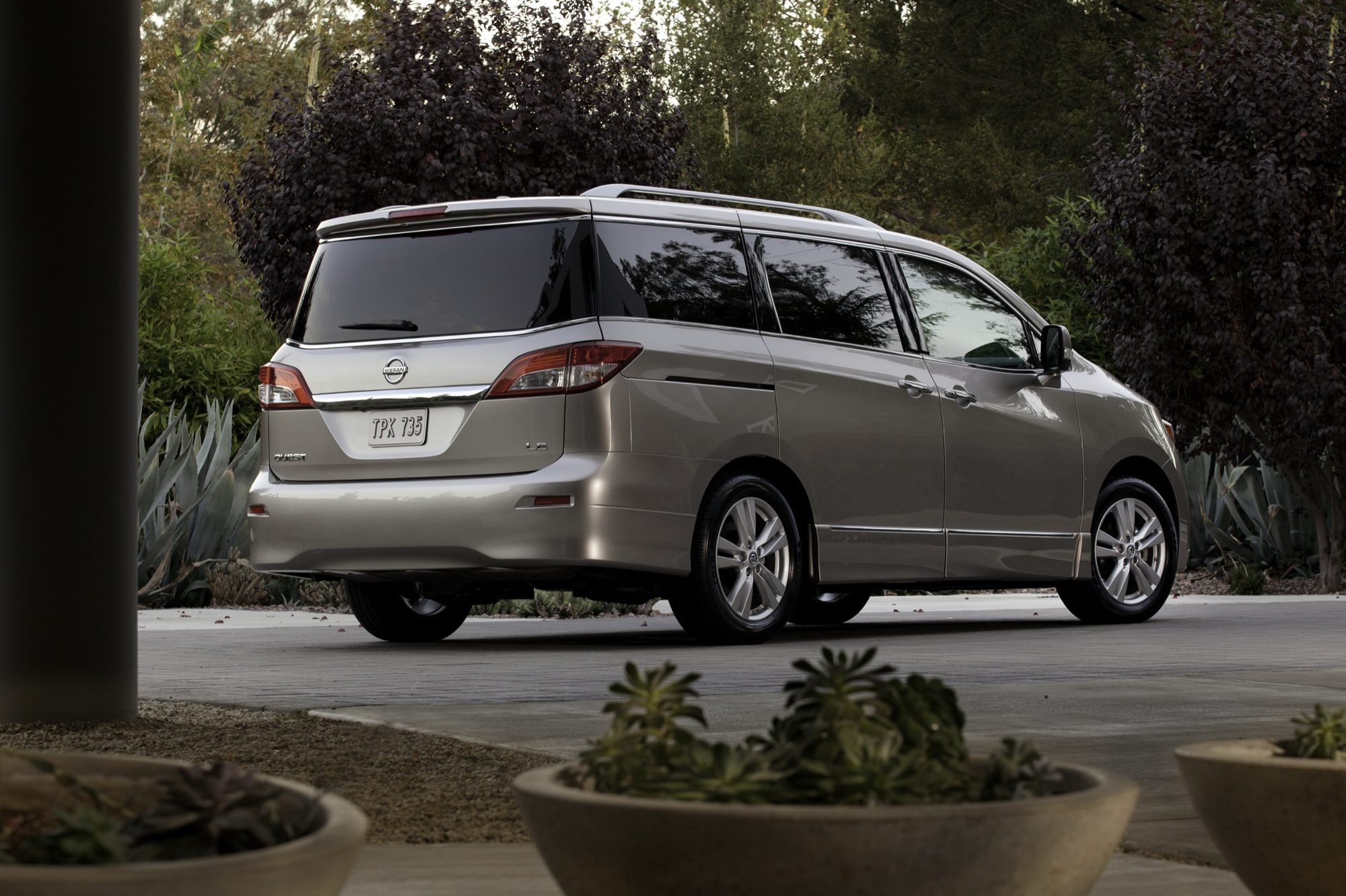 Rear three-quarter view of a champagne 2012 Nissan Quest