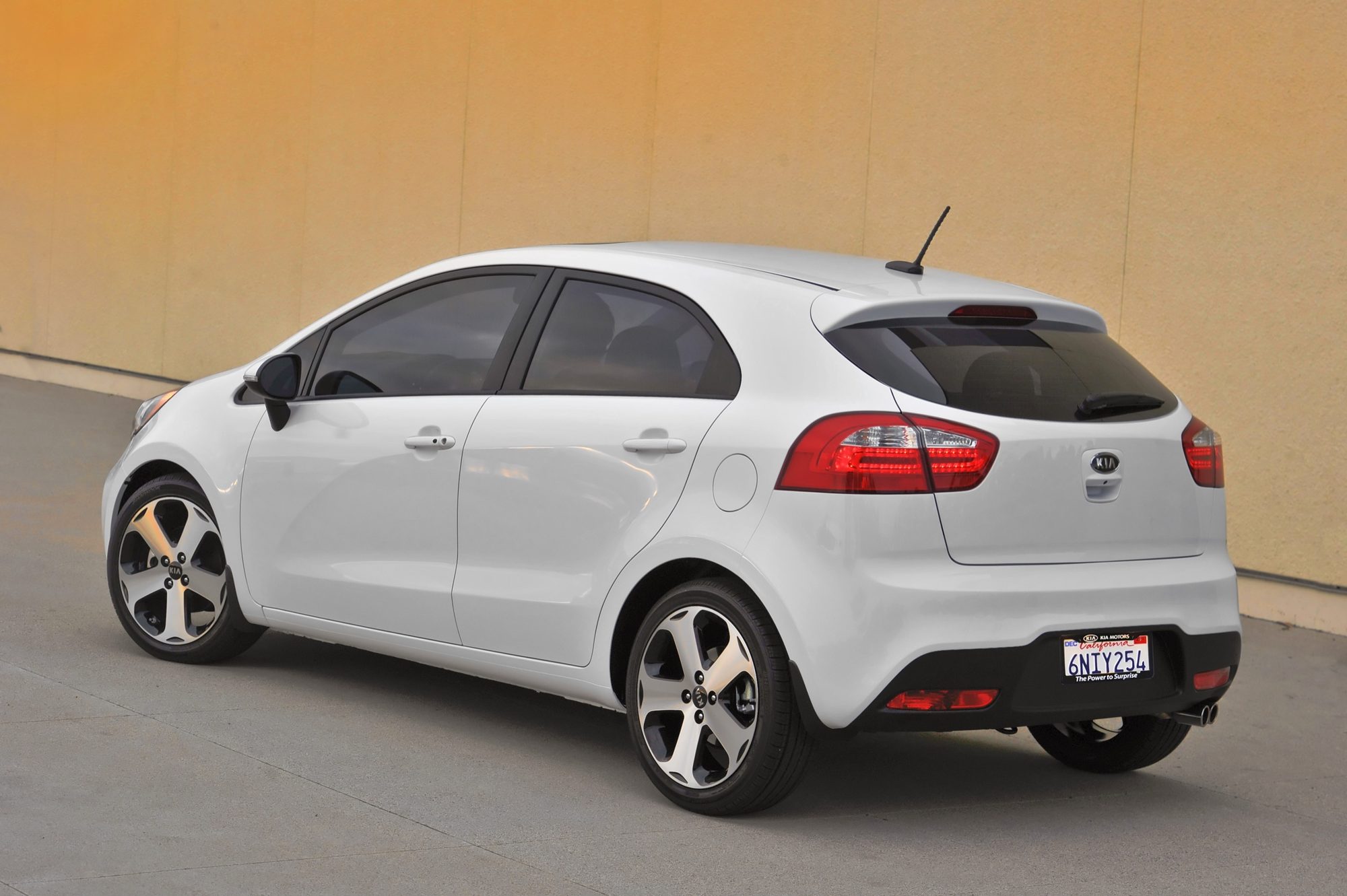 Rear three-quarter view of a white 2013 Kia Rio SX 5-door hatchback