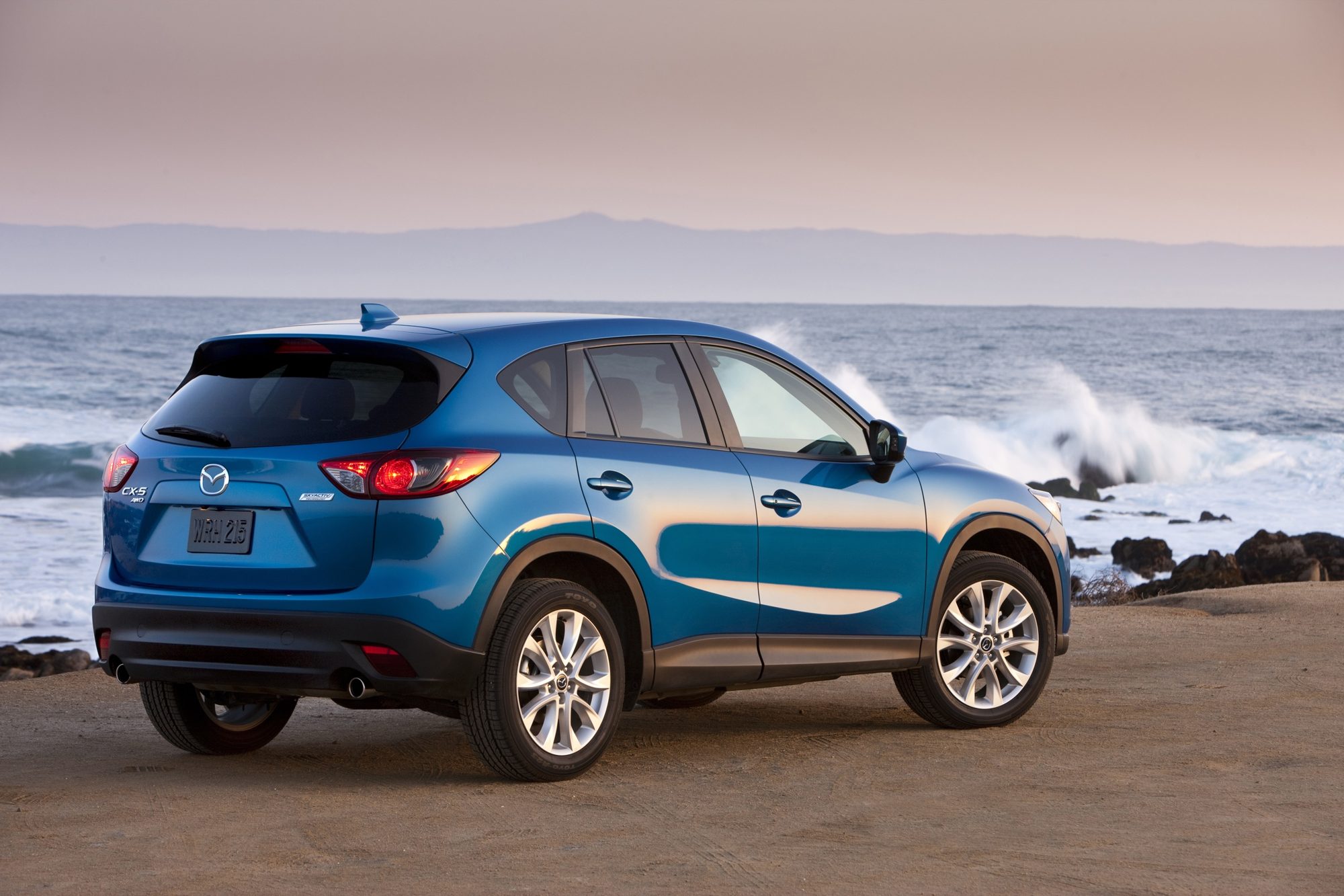 Rear three-quarter view of a blue 2013 Mazda CX-5 AWD with the Skyactiv Technology badge on the liftgate