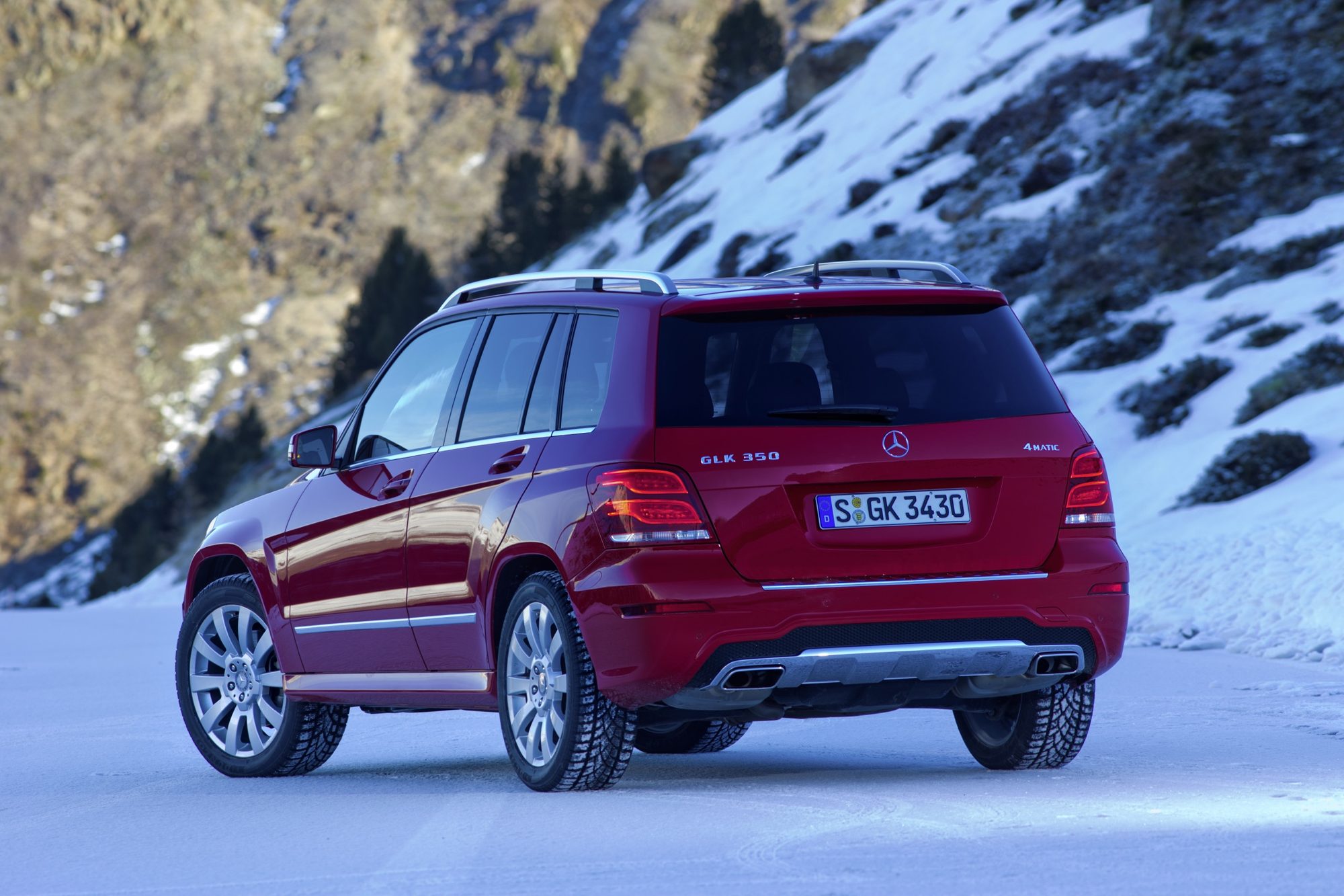Rear three-quarter view of a red 2013 Mercedes-Benz GLK350 4MATIC in the snow