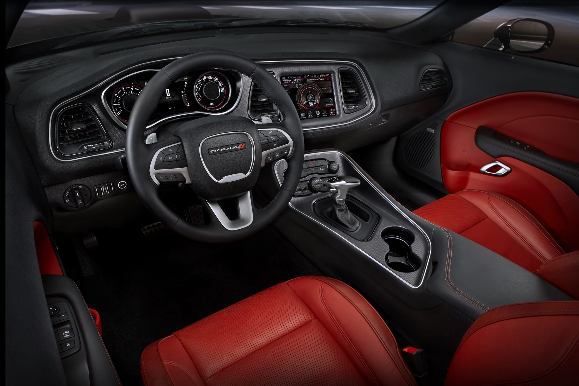 Ruby Red and black leather interior of the 2015 Dodge Challenger SXT Plus with the 8.4-inch touchscreen and eight-speed shifter