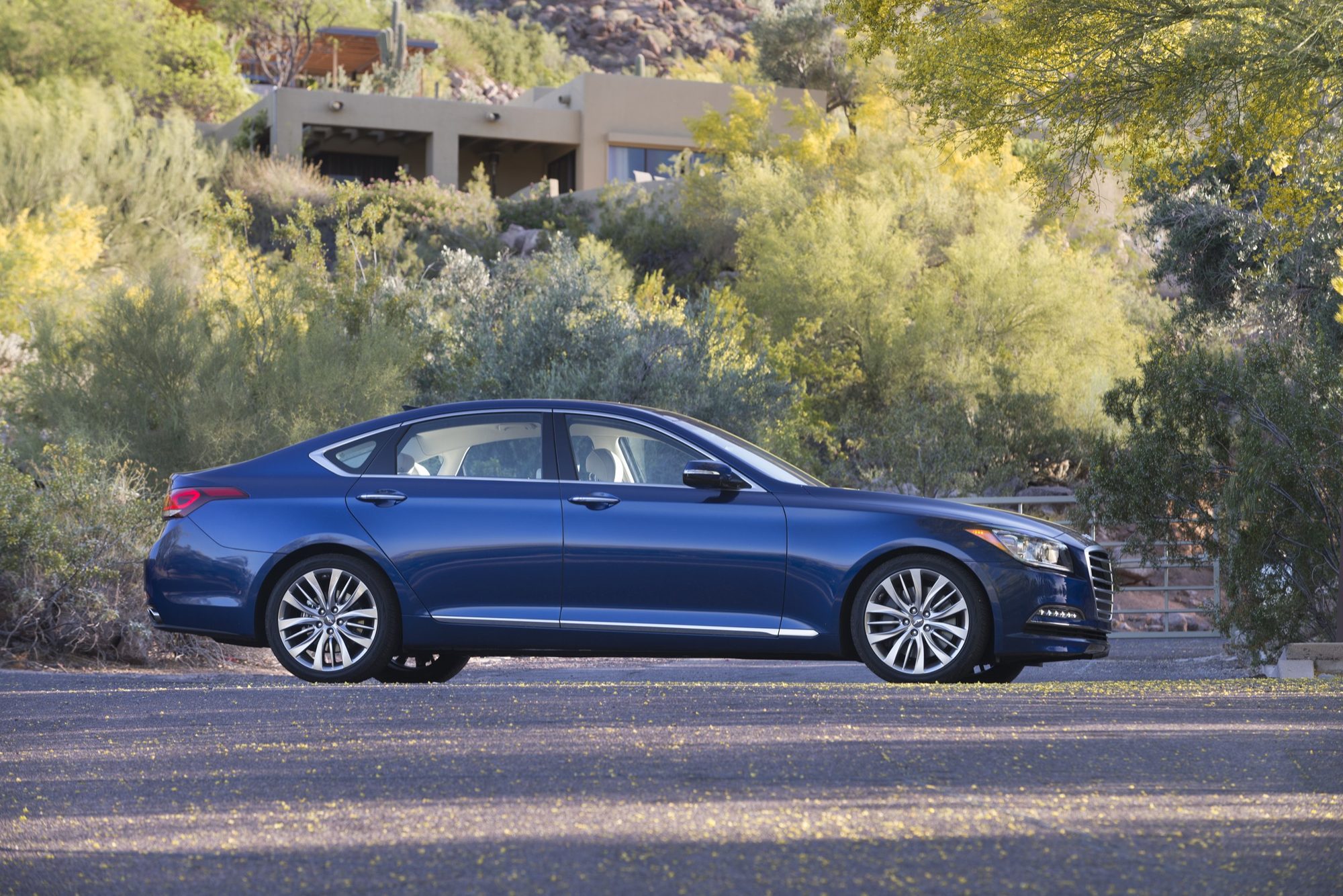 Side profile of a blue 2015 Hyundai Genesis 5.0 sedan parked in the Arizona desert