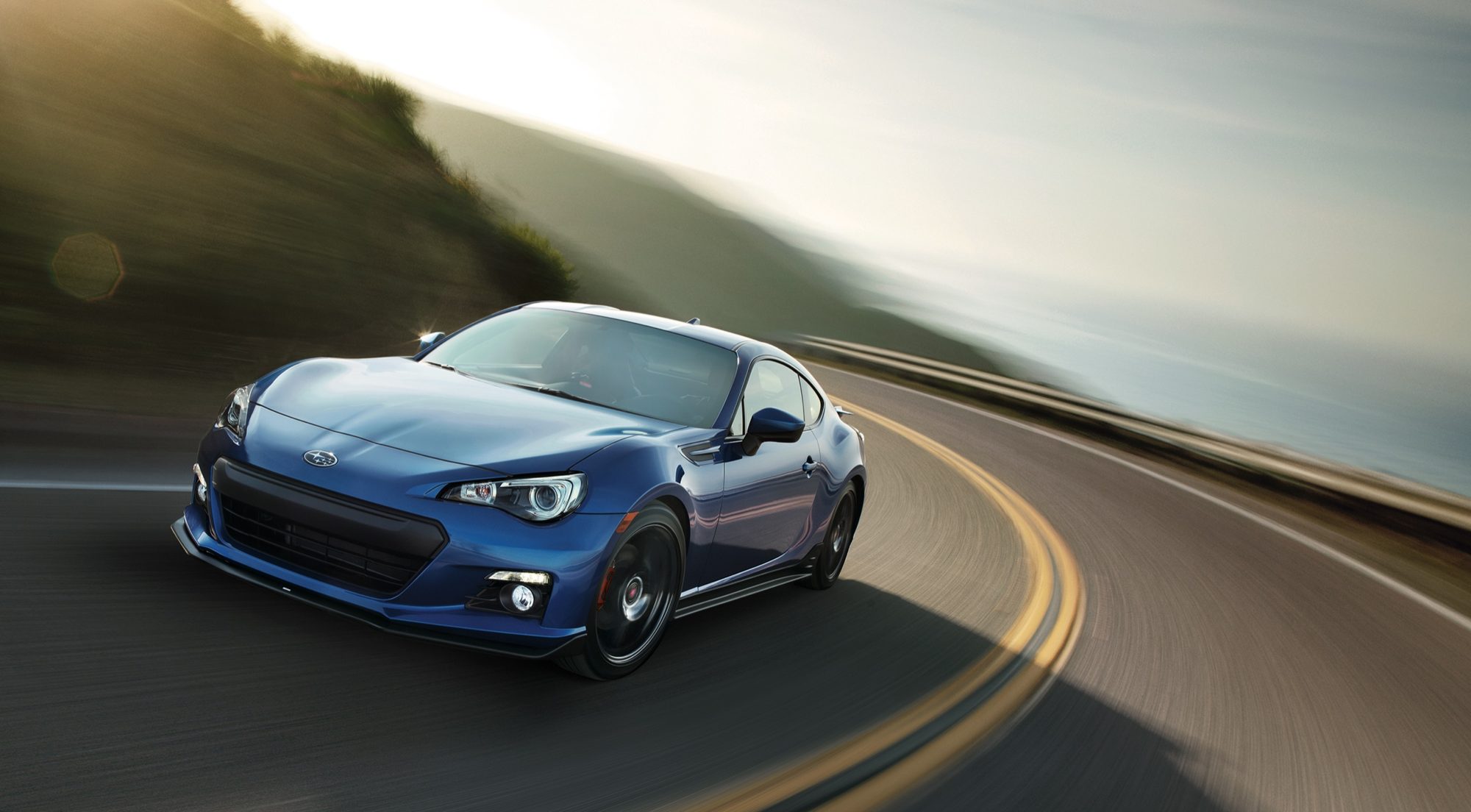 Blue 2015 Subaru BRZ Series.Blue cornering on a coastal road