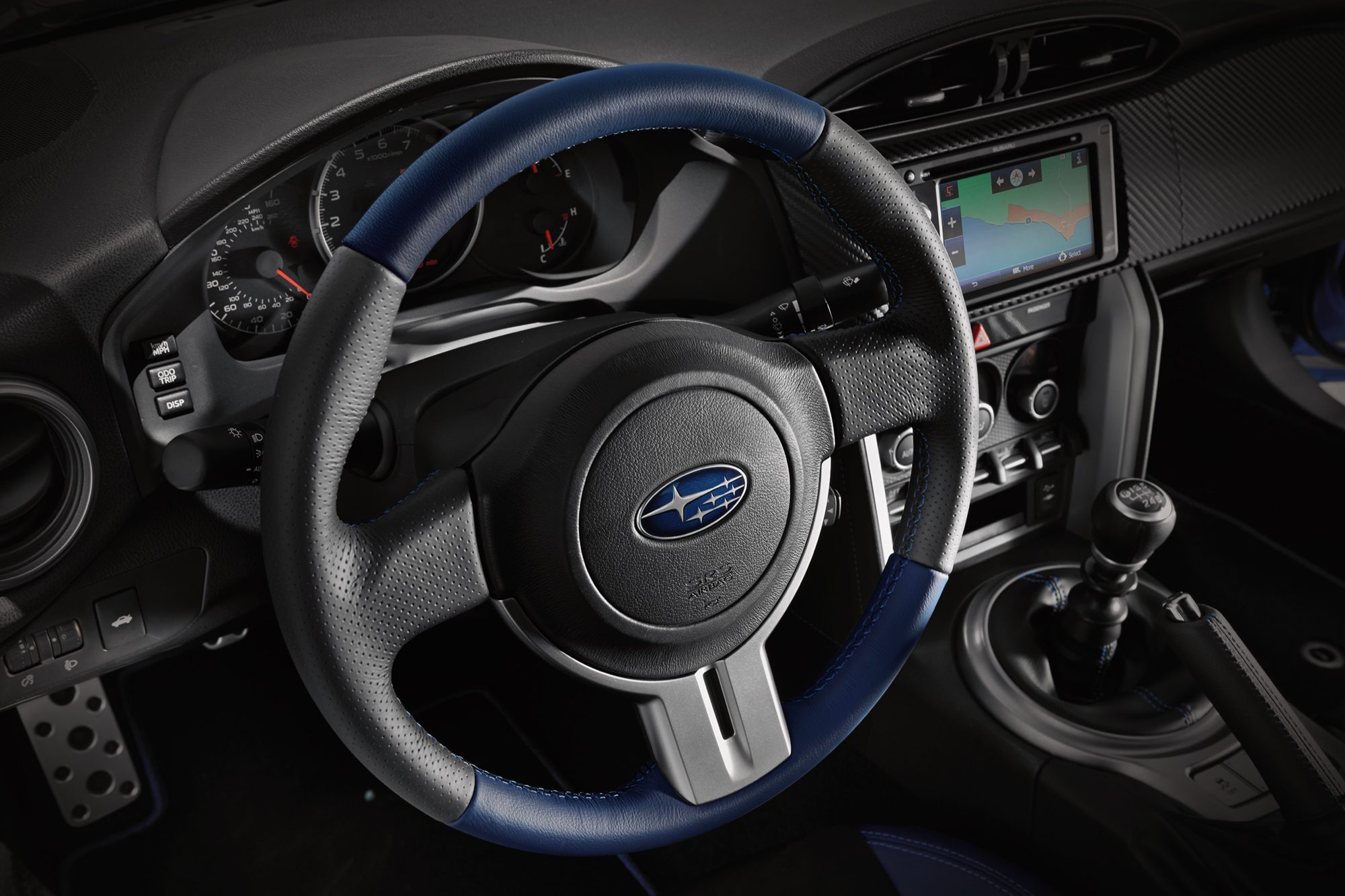 Blue-and-black leather steering wheel and manual shifter in the 2015 Subaru BRZ Series.Blue