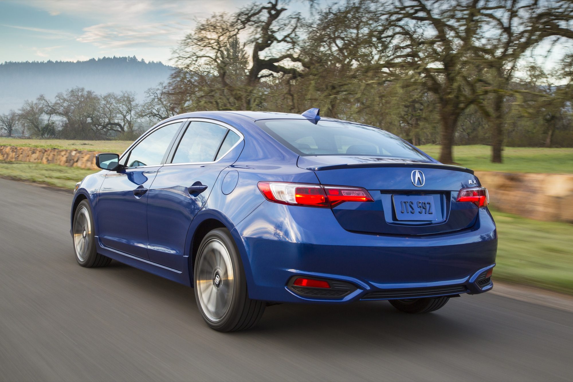 Rear three-quarter view of a blue 2016 Acura ILX A-Spec driving