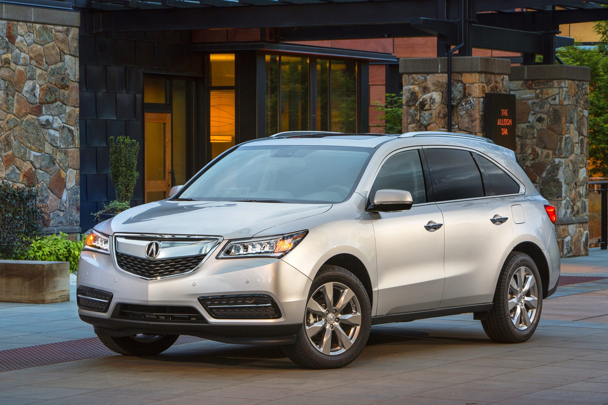 Silver 2016 Acura MDX parked in front of a lodge at dusk