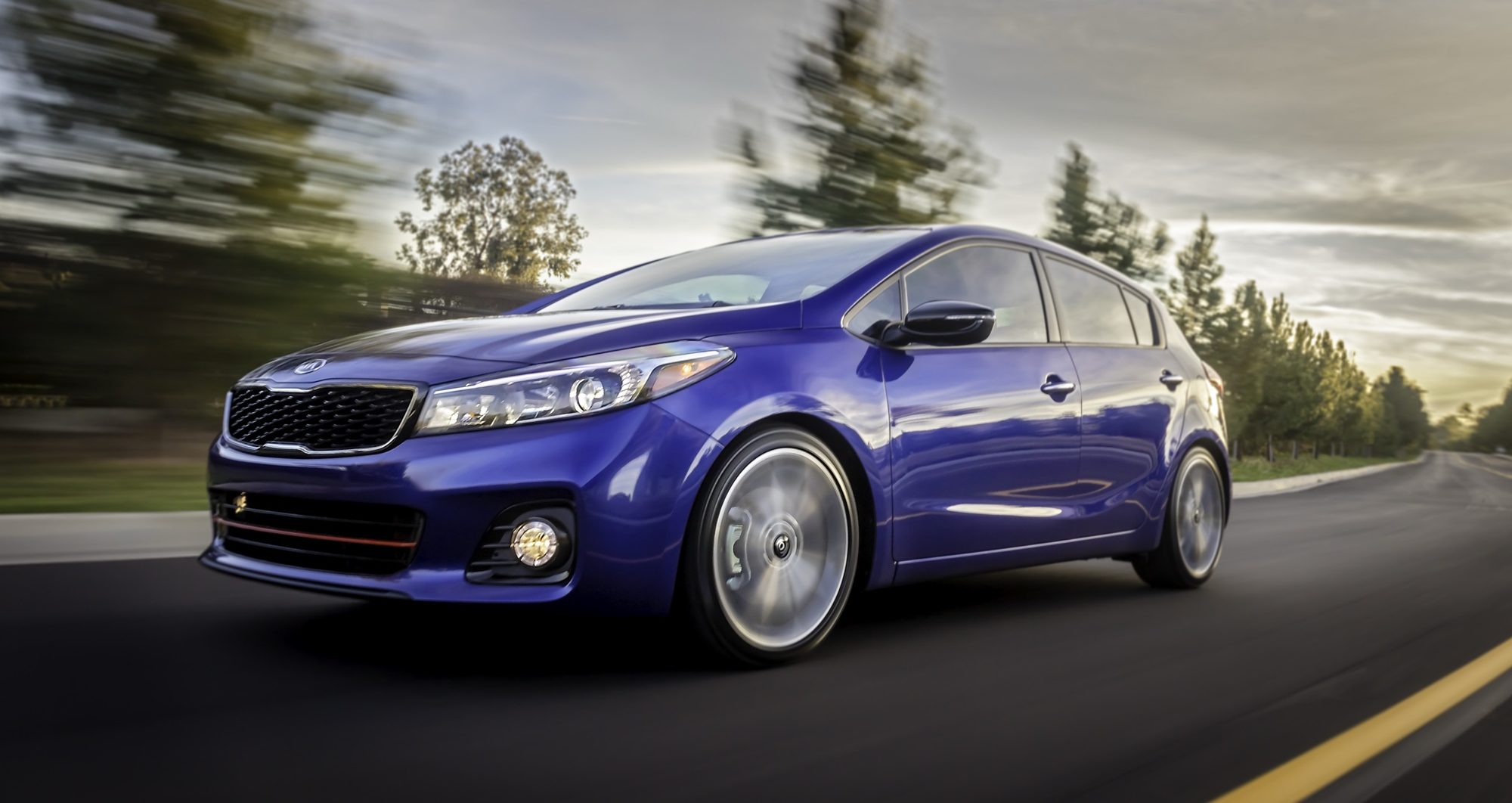 Blue 2017 Kia Forte5 SX driving on a curving road