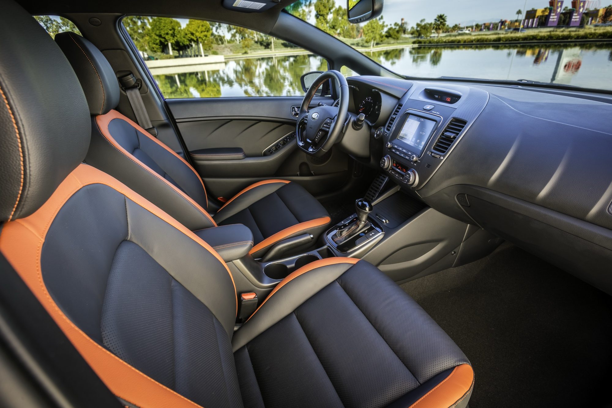 Black leather front seats with orange accents and dashboard of the 2017 Kia Forte5 SX
