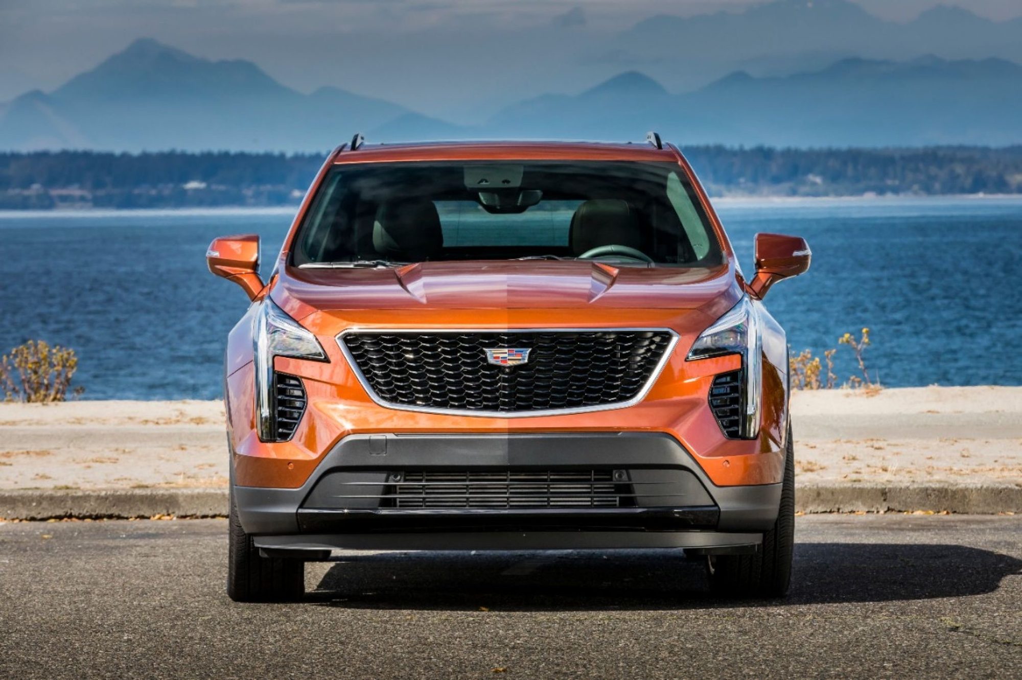 Front view of an orange 2019 Cadillac XT4 Sport with its black mesh grille