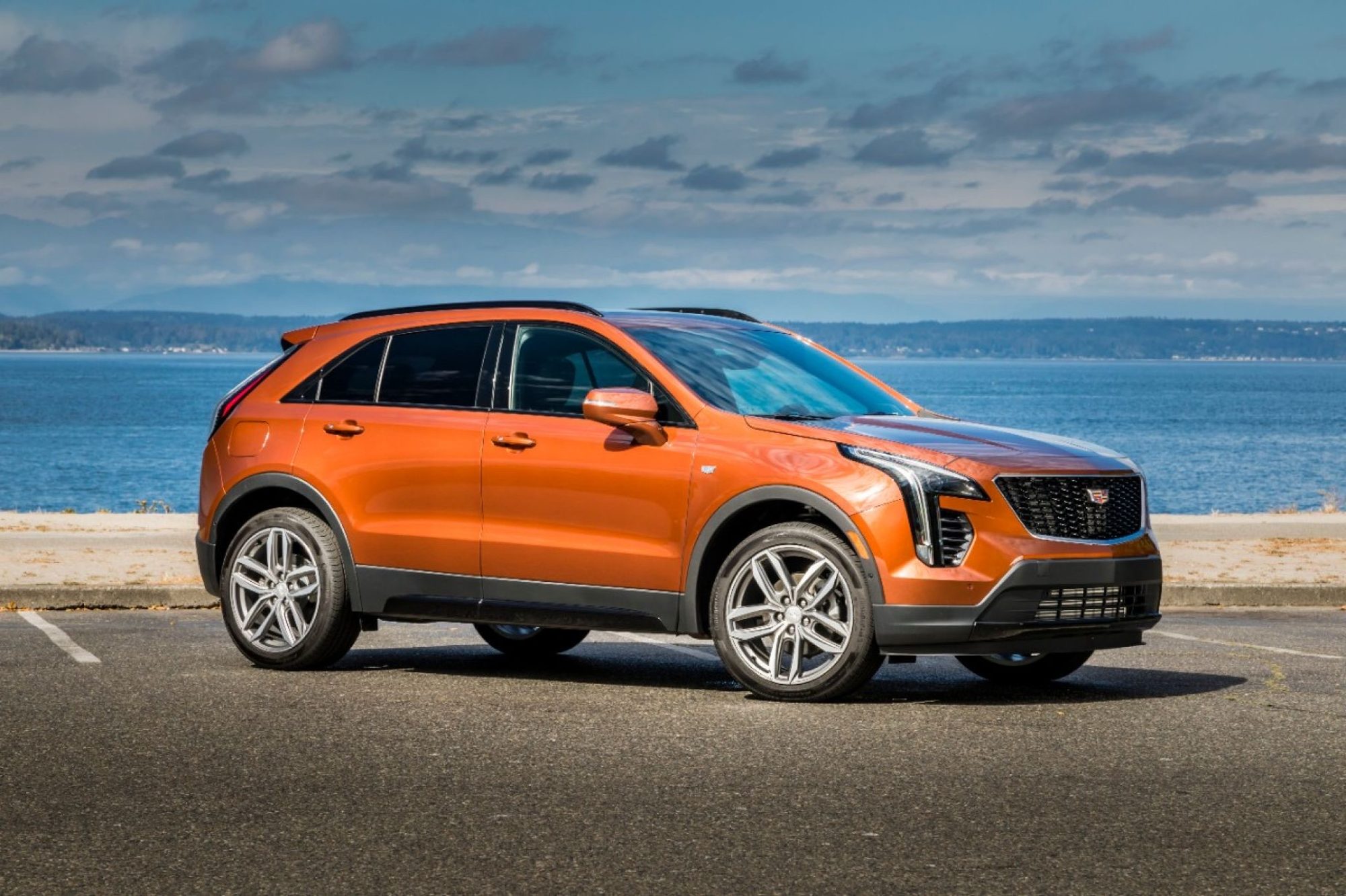 Orange 2019 Cadillac XT4 Sport parked by the water