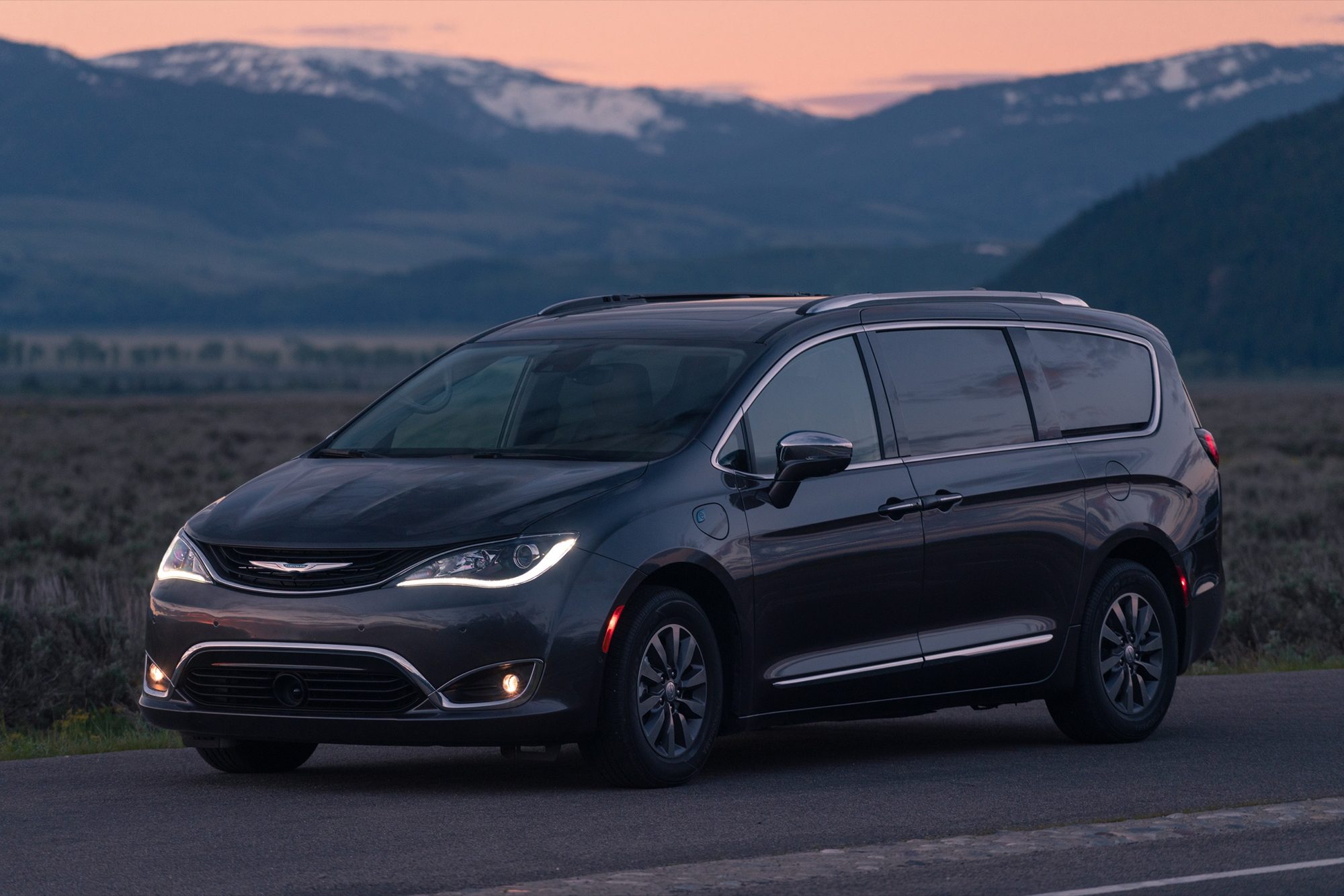 Front three-quarter view of a gray 2019 Chrysler Pacifica Hybrid Limited at dusk
