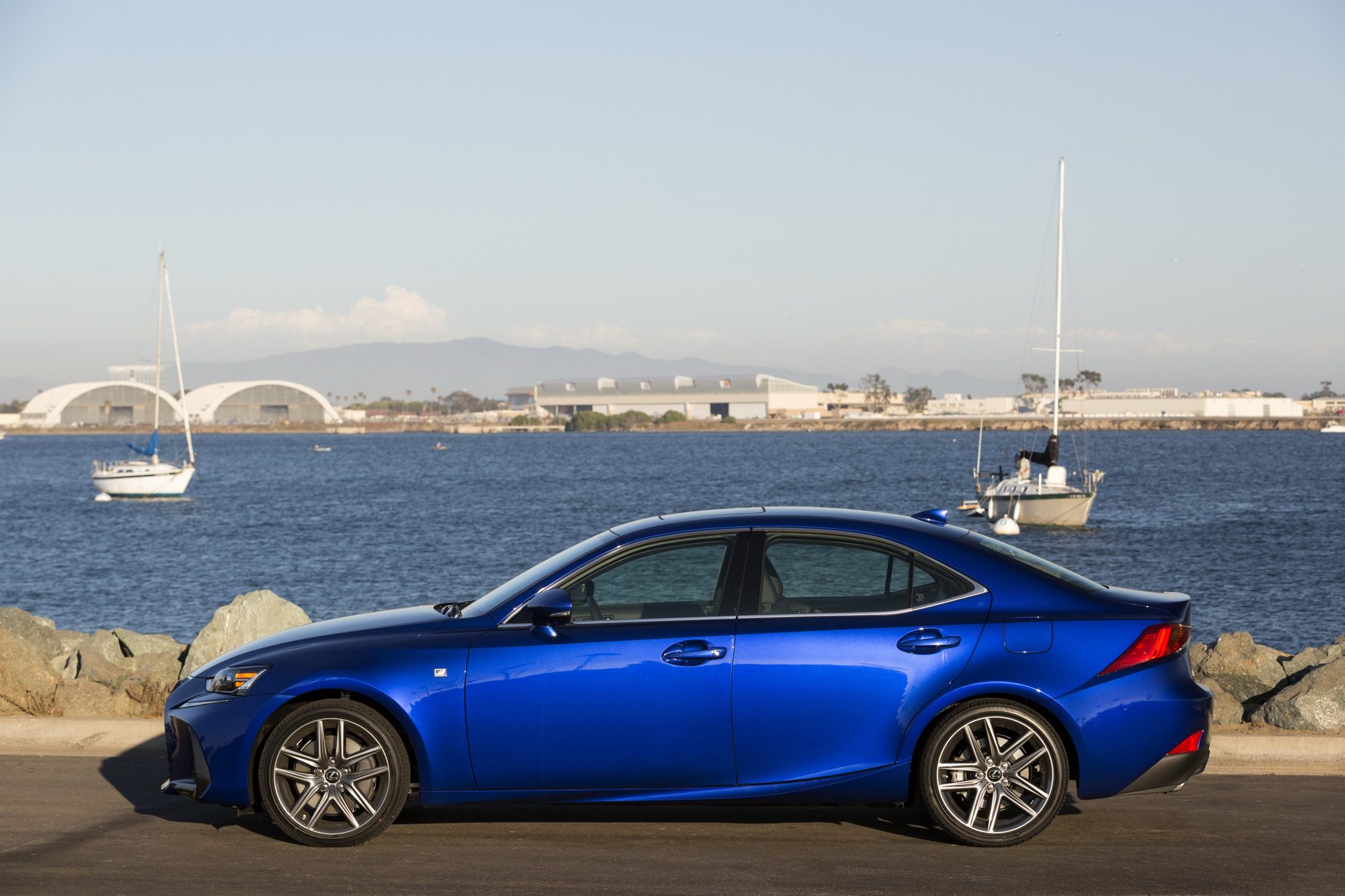 Side profile of a blue 2019 Lexus IS 350 F Sport parked by a marina