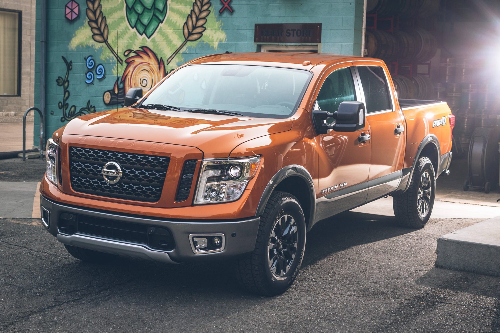 2019 Nissan Titan Review: Tough competitors, tough road ahead 2 Front three-quarter view of an orange 2019 Nissan Titan PRO-4X crew cab beside a mural