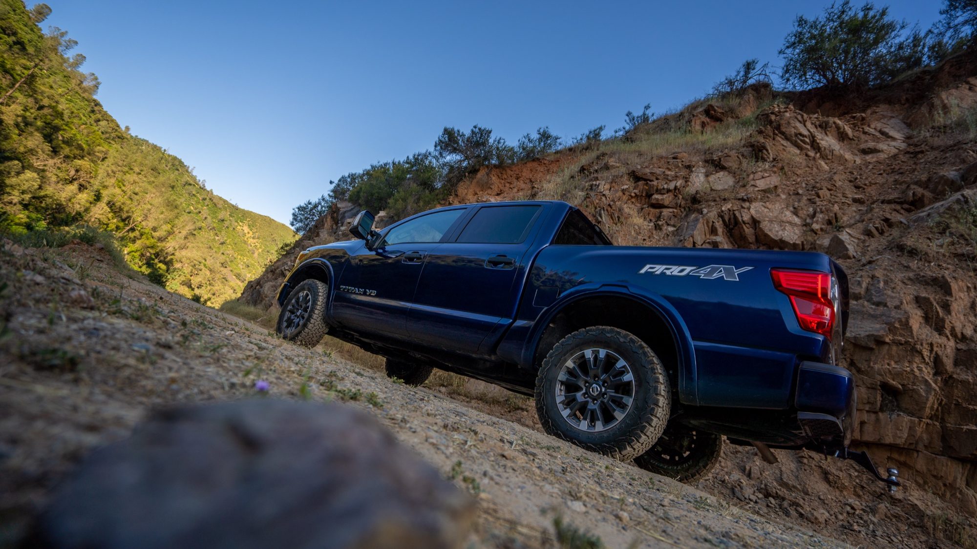 Blue 2019 Nissan Titan PRO-4X climbing a dirt trail