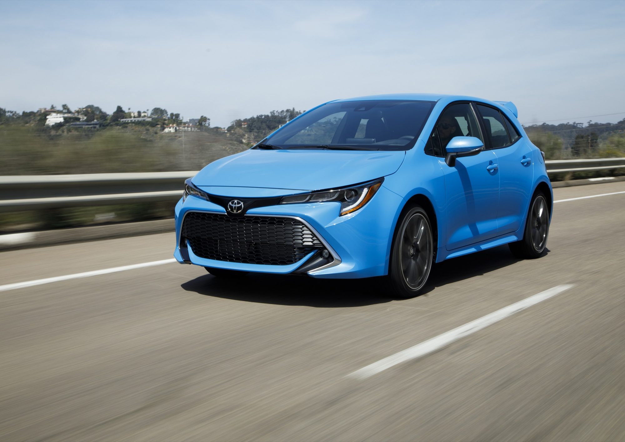 2019 Toyota Corolla Hatchback XSE in Blue Flame driving on a highway