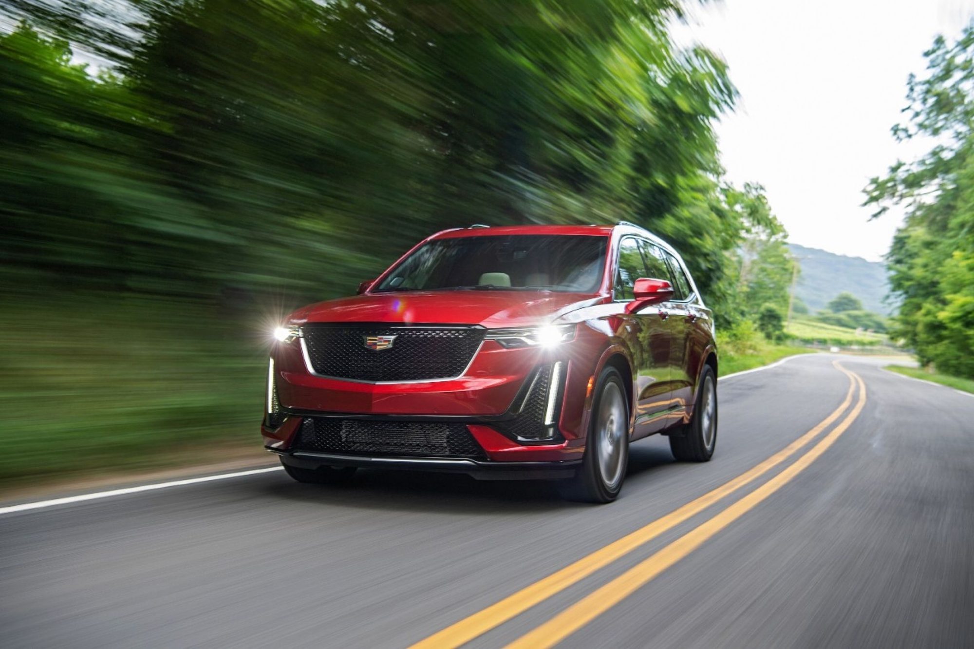 Red 2020 Cadillac XT6 Sport driving on a winding road