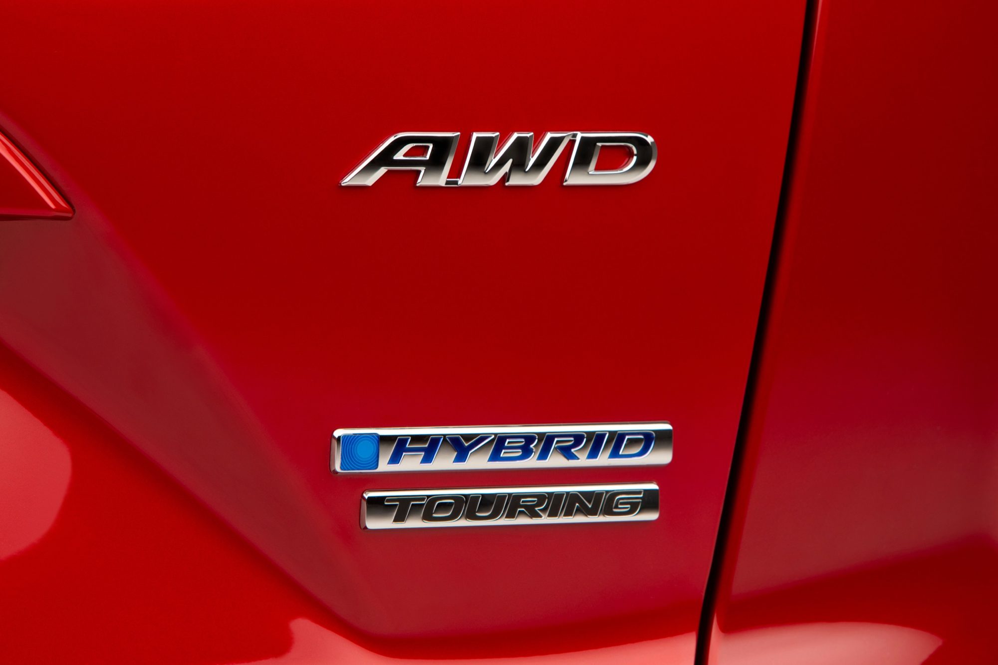 Blue-trimmed Hybrid and Touring badges with an AWD badge on the 2020 Honda CR-V Hybrid tailgate