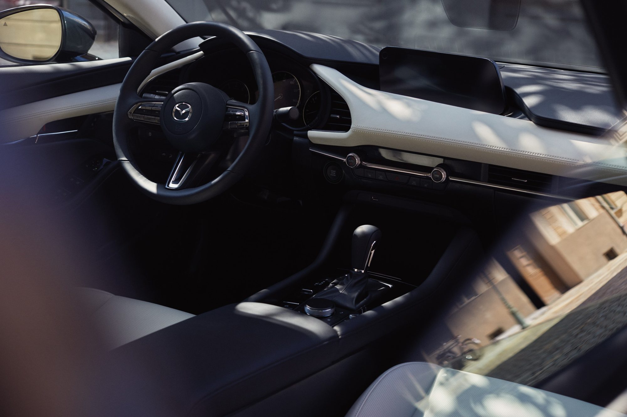 Dashboard and center console of the 2020 Mazda3 sedan with white leather trim