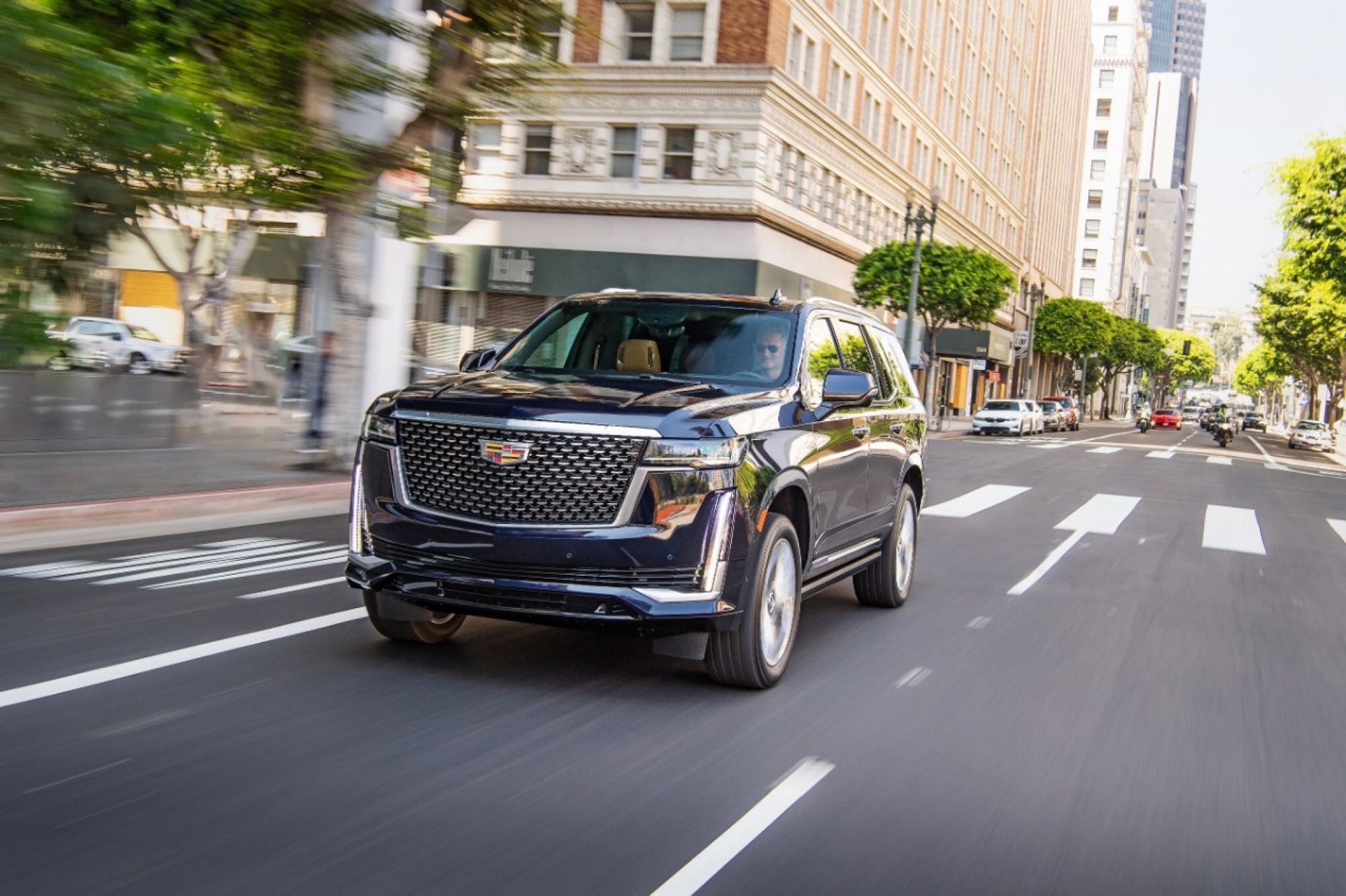 Dark blue 2021 Cadillac Escalade driving on a city street