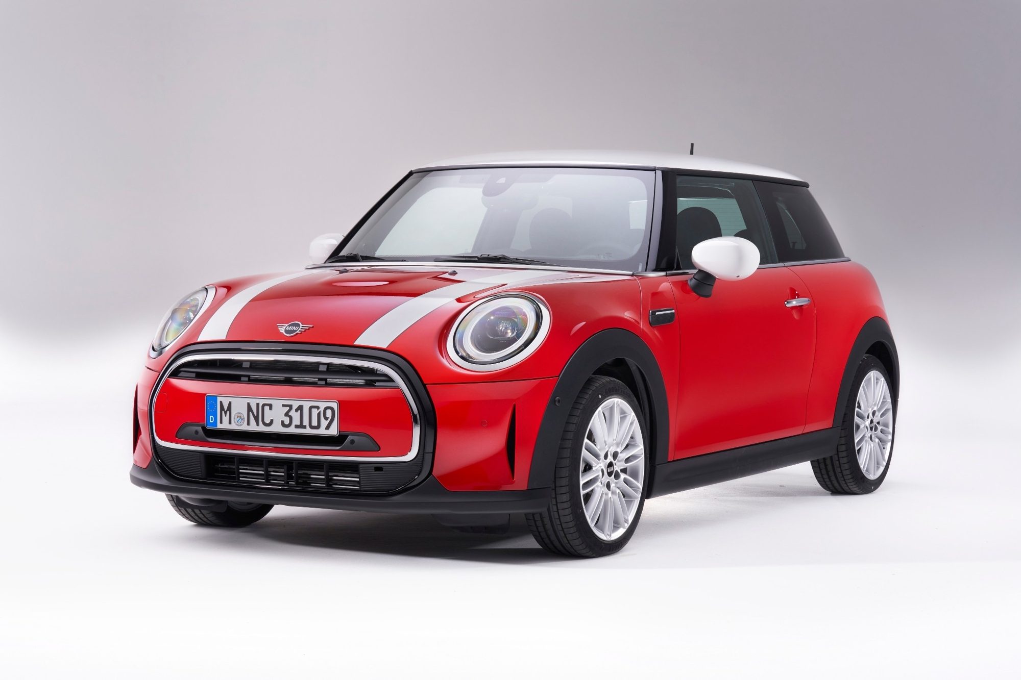 Front three-quarter view of a red 2022 Mini Cooper two-door hardtop with the new grille