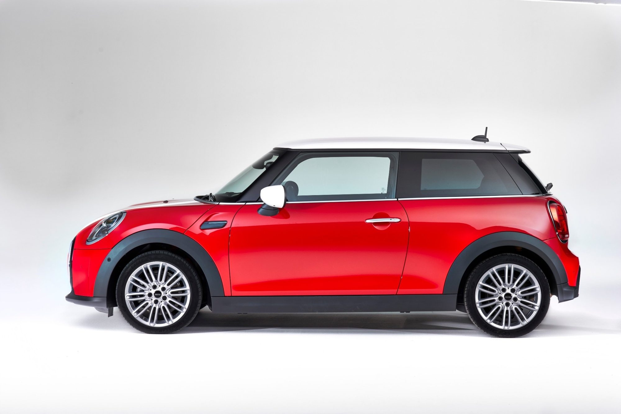 Side profile of a red 2022 Mini Cooper two-door hardtop with a white roof