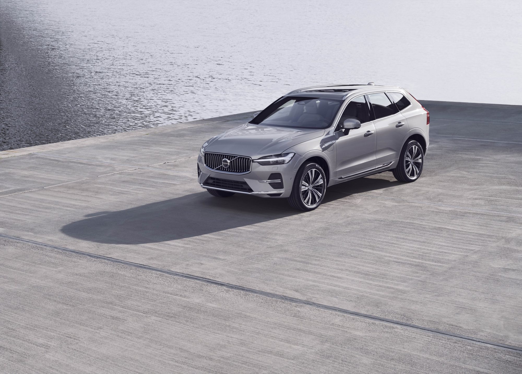 Silver 2022 Volvo XC60 with a chrome grille parked on a concrete pier