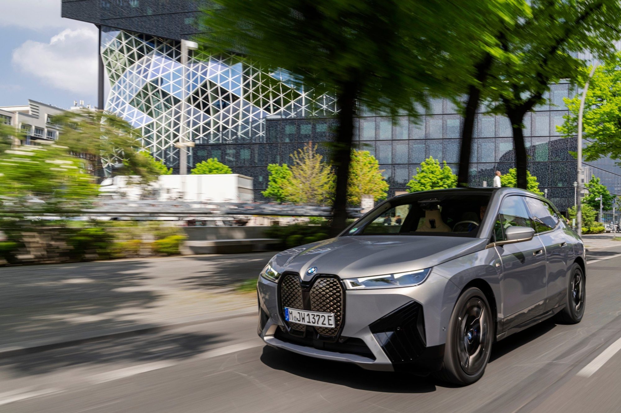 Grey 2023 BMW iX M60 driving on a city street