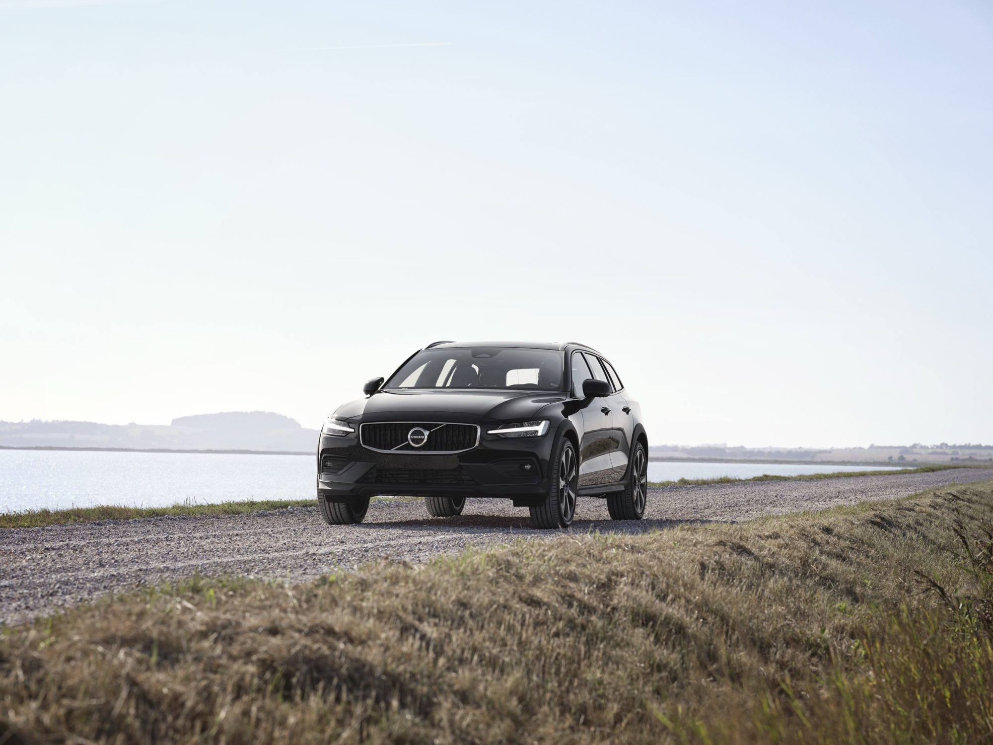 Front view of a 2023 Volvo V60 Cross Country B5 AWD in Onyx Black on a gravel causeway