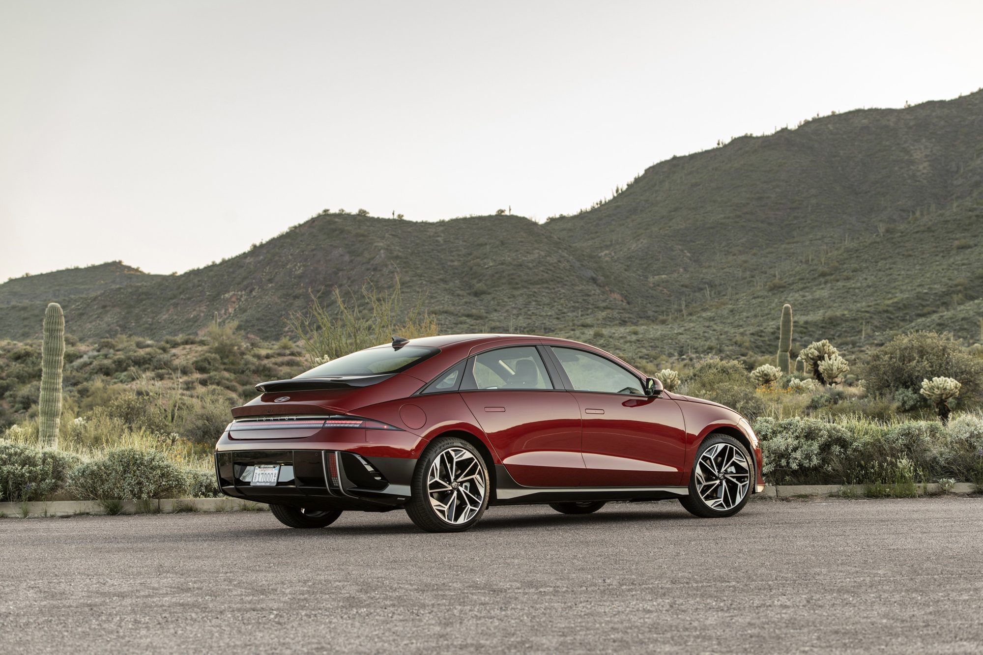 Rear three-quarter view of a red 2024 Hyundai Ioniq 6 Limited showing its curved roofline and rear spoiler