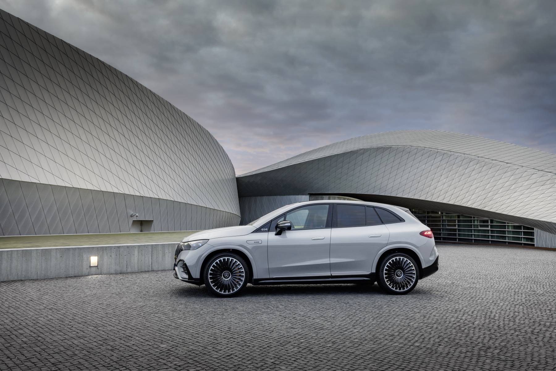 2024 Mercedes-AMG EQE SUV Review: Luxury, utility, performance, pricey 6 Silver 2024 Mercedes-AMG EQE SUV parked in front of a curved modern building