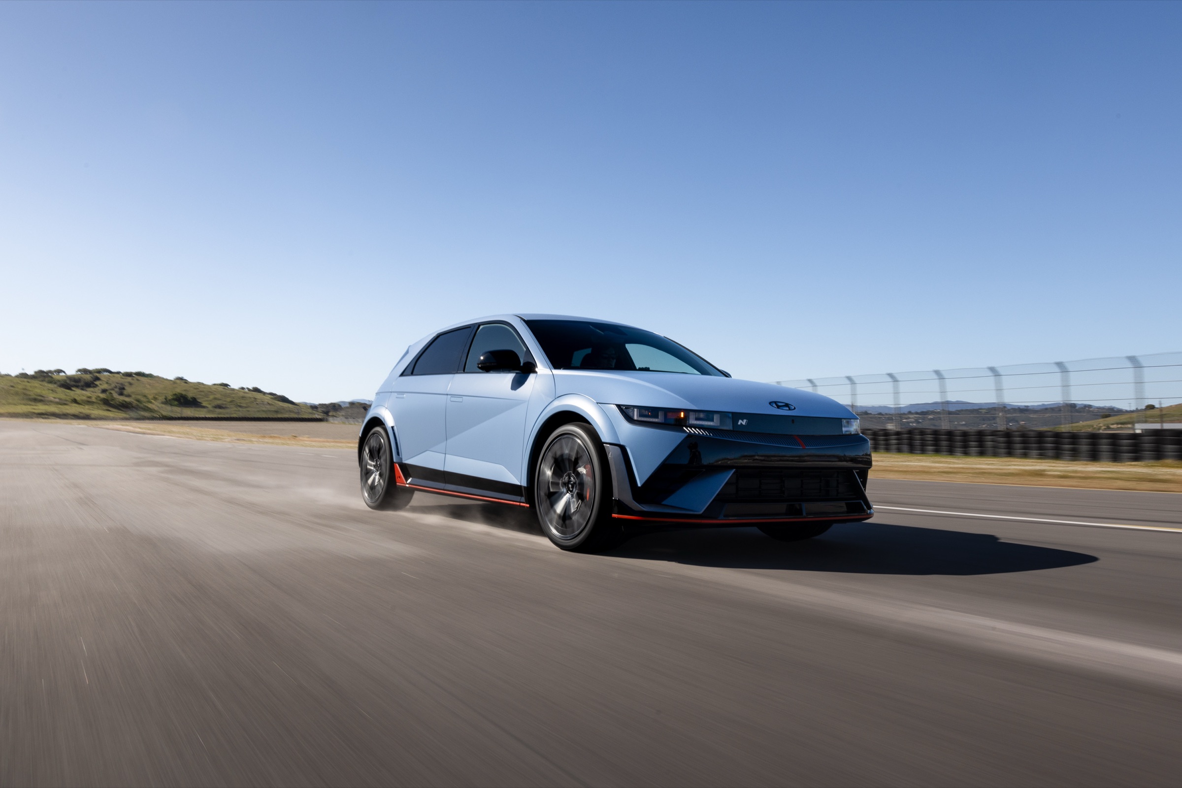 Light blue 2026 Hyundai Ioniq 5 N driving on a racetrack, front three-quarter view