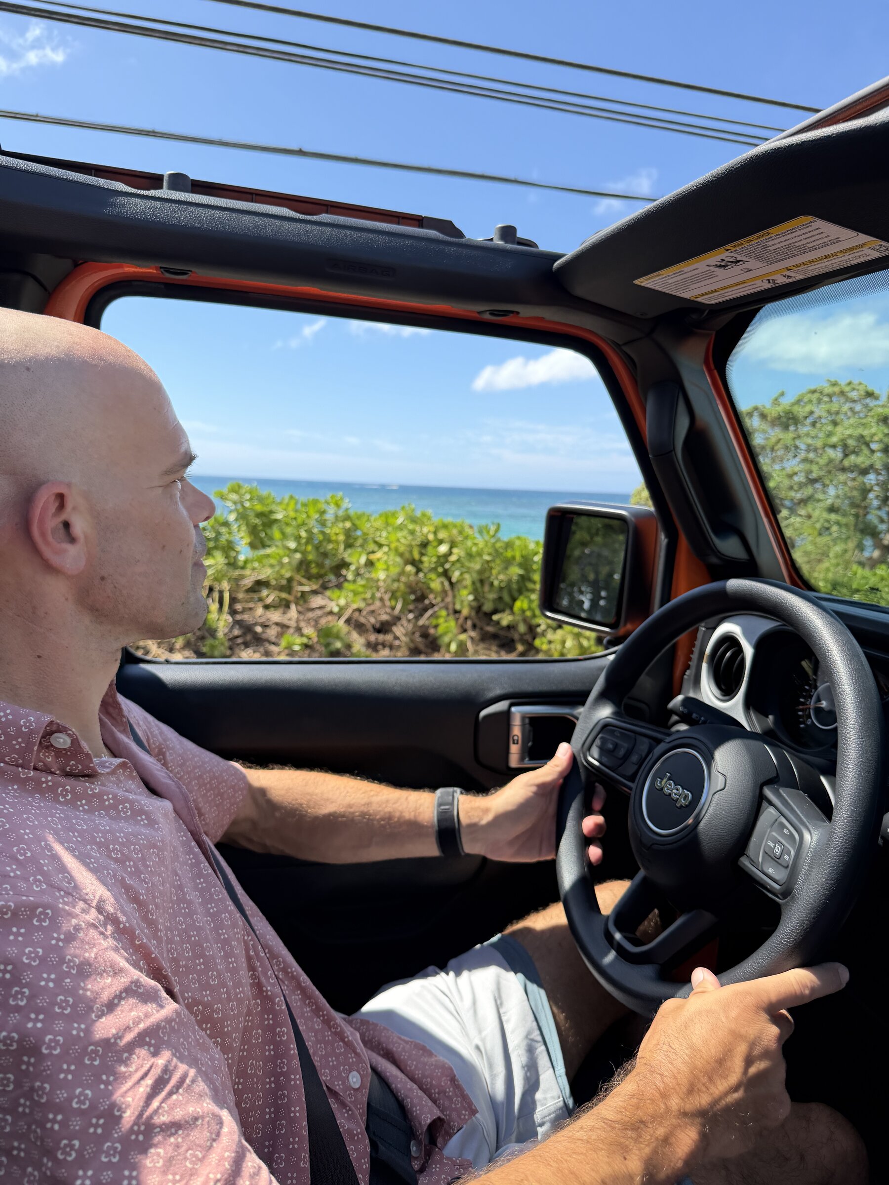 Driving the 2026 Jeep Wrangler Sport along Oahu's North Shore with the soft top folded back