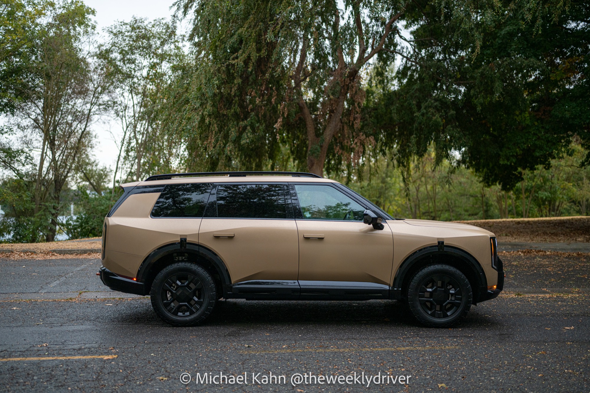 2027 Kia Telluride X-Pro front view with black block grille, vertical LED headlights, amber light bars and orange recovery hooks