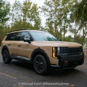 2027 Kia Telluride X-Pro SX-Prestige in Terrain Brown Matte, front three-quarter view on a wet parking lot