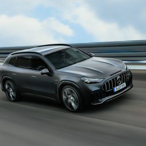 Gray 2028 Mercedes-AMG GT SUV driving on a test track with a blurred guardrail behind it