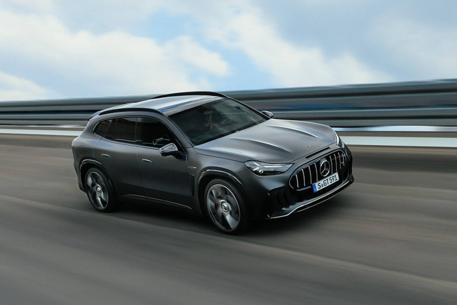 Gray 2028 Mercedes-AMG GT SUV driving on a test track with a blurred guardrail behind it