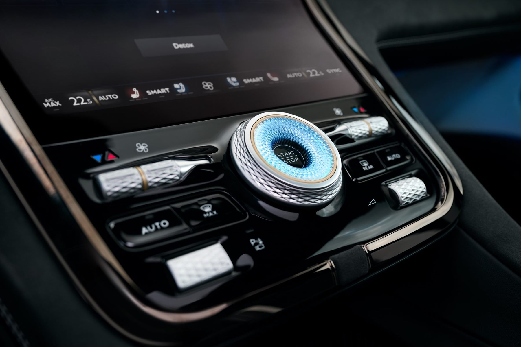 Close-up of the Bentley Torcal center console with a knurled rotary controller and rows of metal switches
