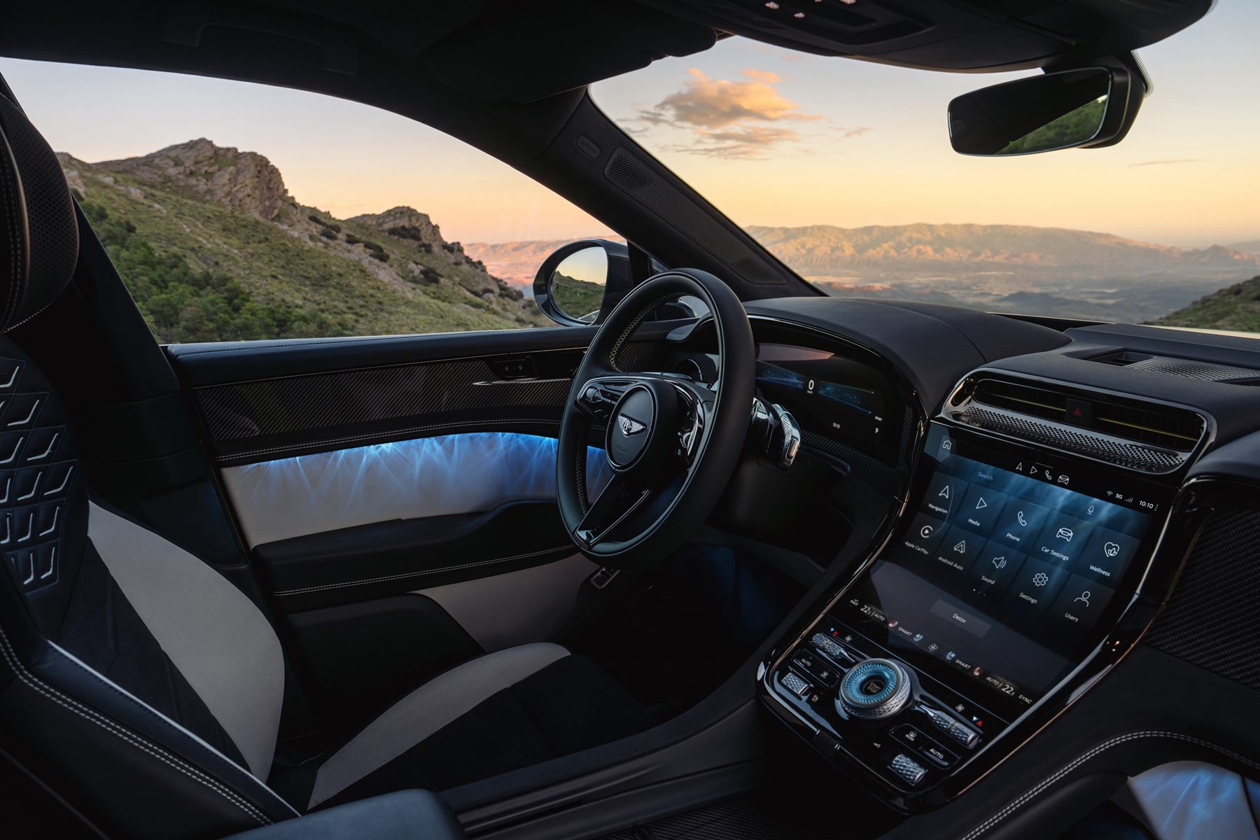 Bentley Torcal interior showing the curved dashboard display, steering wheel and blue ambient lighting