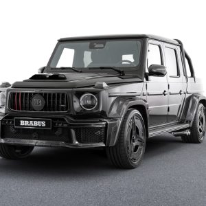 Black Brabus P 900 Rocket Edition pickup built from a Mercedes-AMG G 63, front three-quarter studio view showing the carbon widebody, roll bar and 24-inch wheels